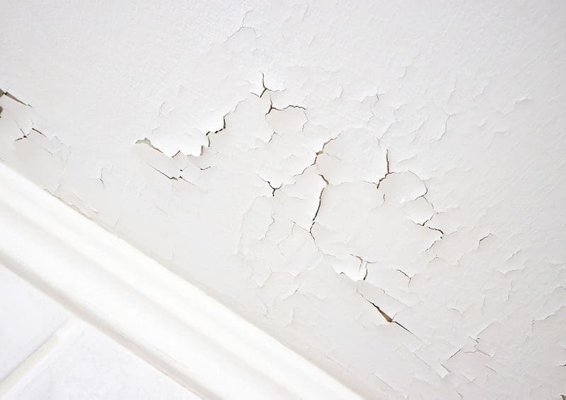 Swelling leaking of whitewash and plaster on ceiling of basement due to penetration of water from the top floor.